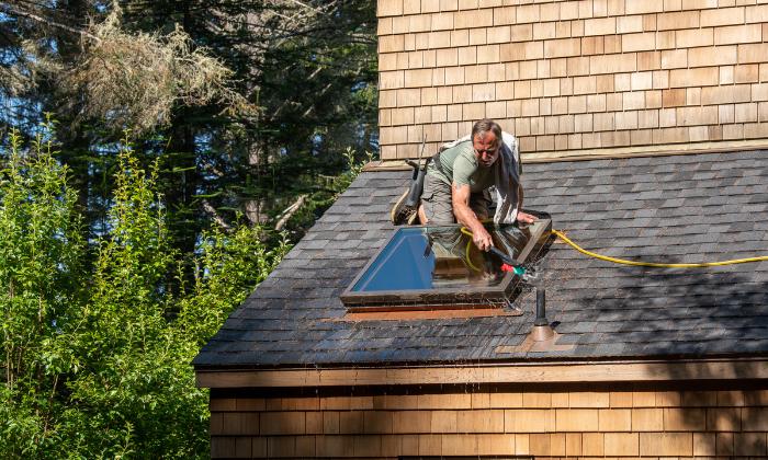 A man cleaning roof tiles