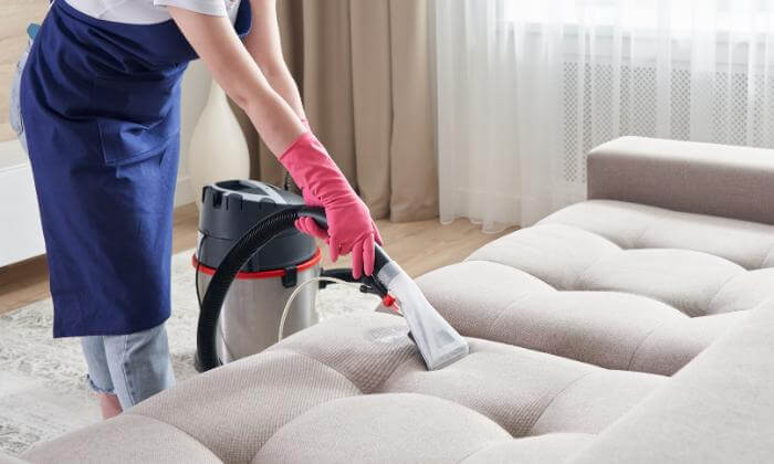 Woman cleaning the sofa